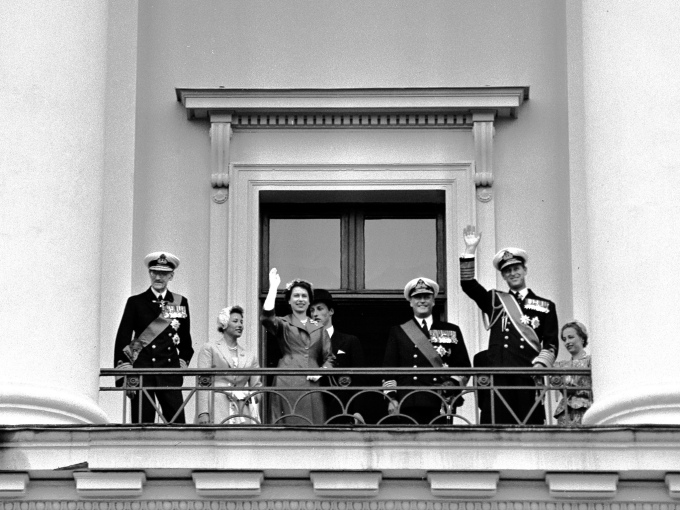 Dronning Elizabeth og Hertugen av Edinburgh hilser fra Slottsbalkongen under statsbesøk til Norge i 1955. Her sammen med Kong Haakon, Prinsesse Astrid, Prins Harald, Kronprins Olav og Prinsesse Ragnhild. Foto: NTB arkiv 
